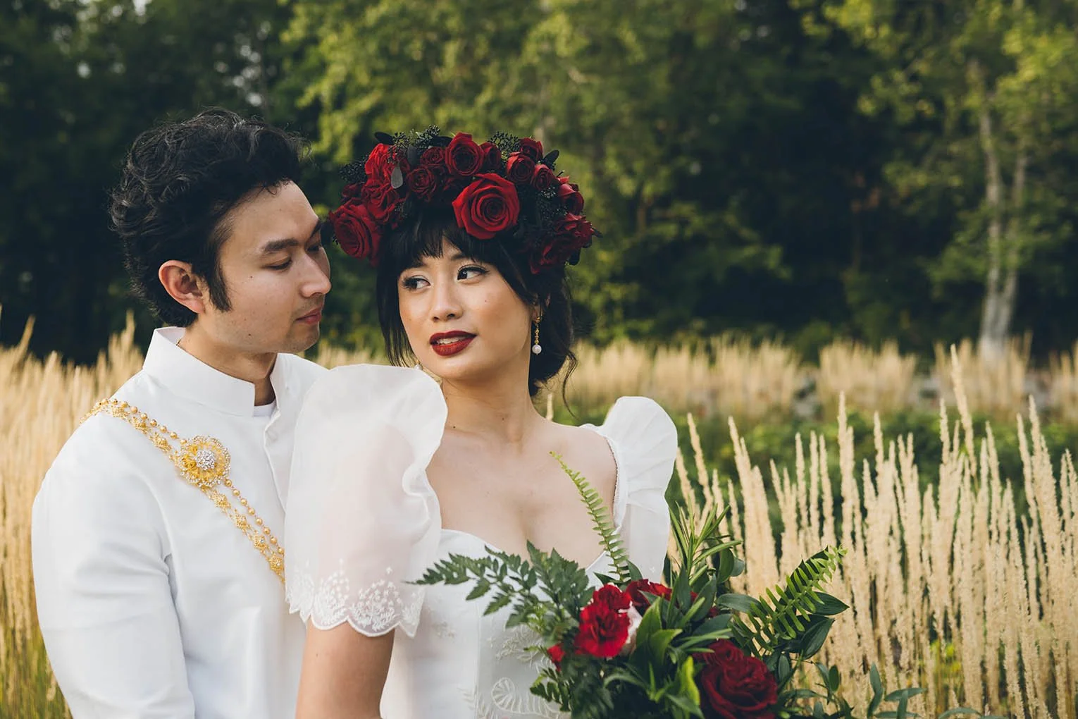 photo of bride and groom outdoors with red flowers