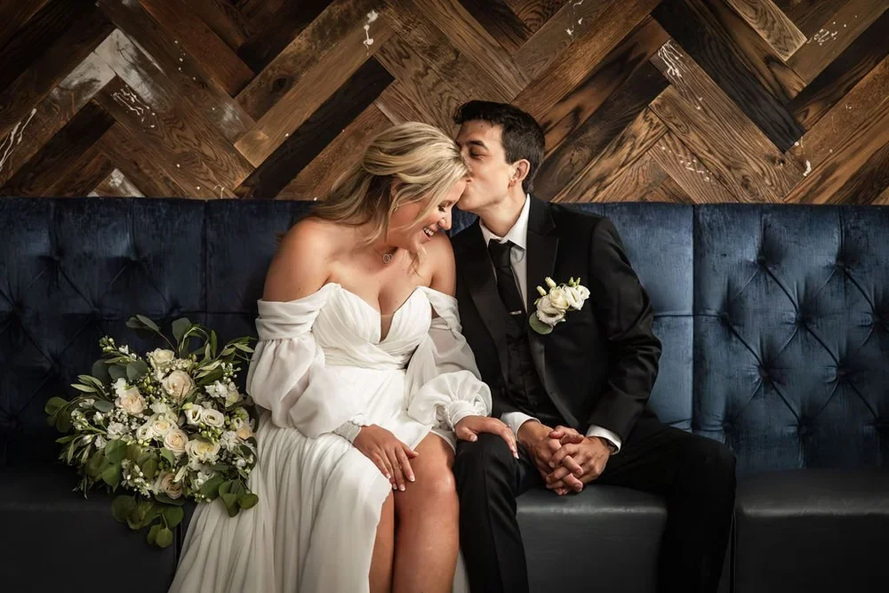 Photo of bride and groom on a leather couch