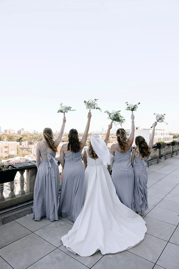 Photo of bride and bridesmaids on a city rooftop