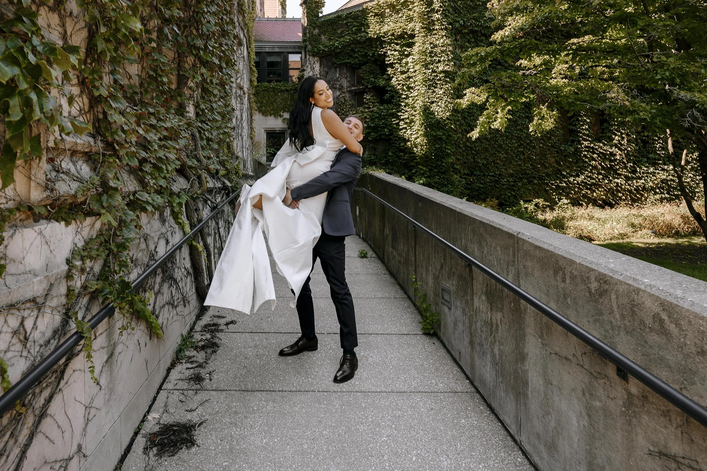 groom picking up bride while on a walk outside