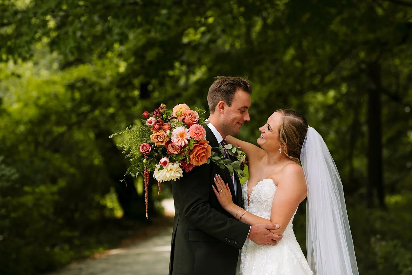 Photo of bride and groom with big bouquet of flowers