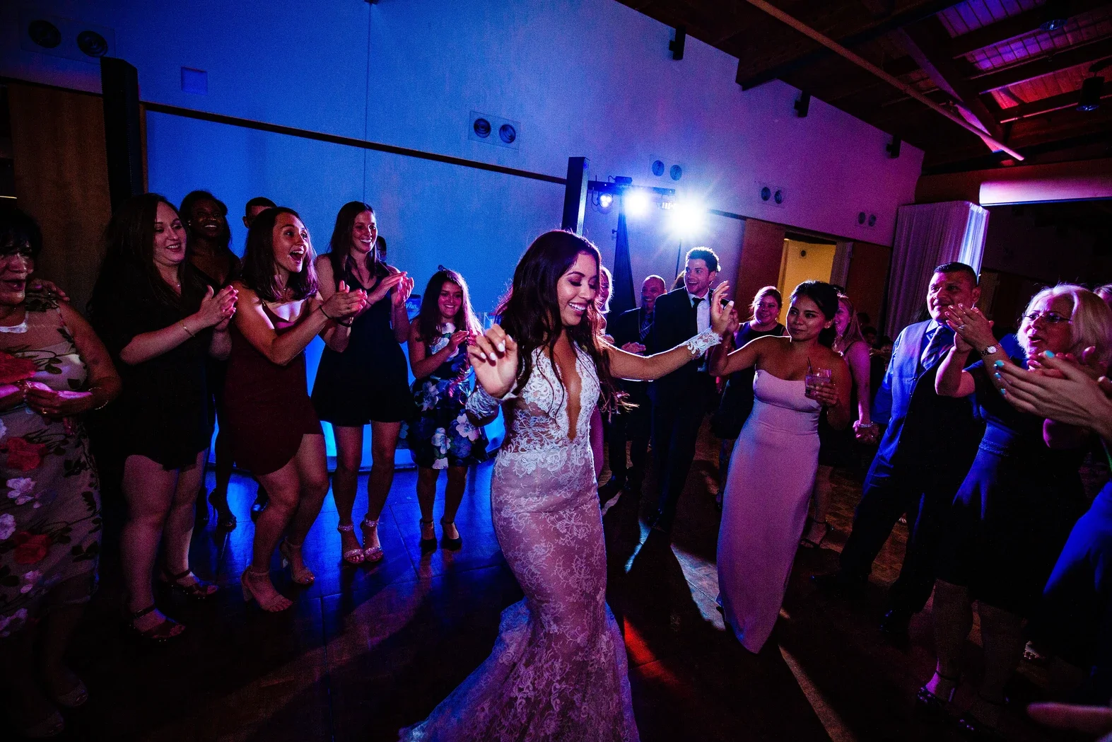 people surrounding the bride dancing at a wedding