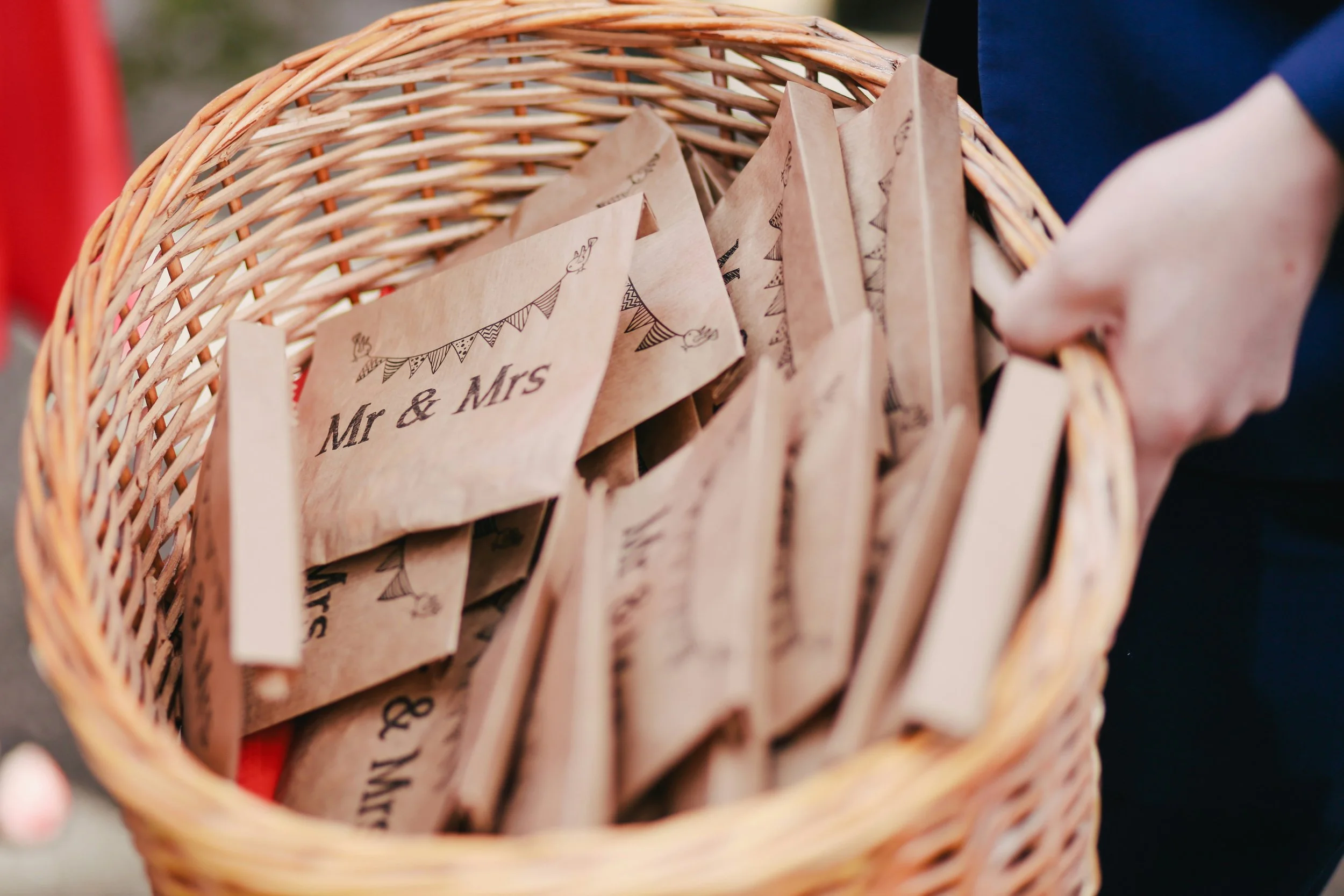 a basked full of cardboard envelopes for the bride and groom