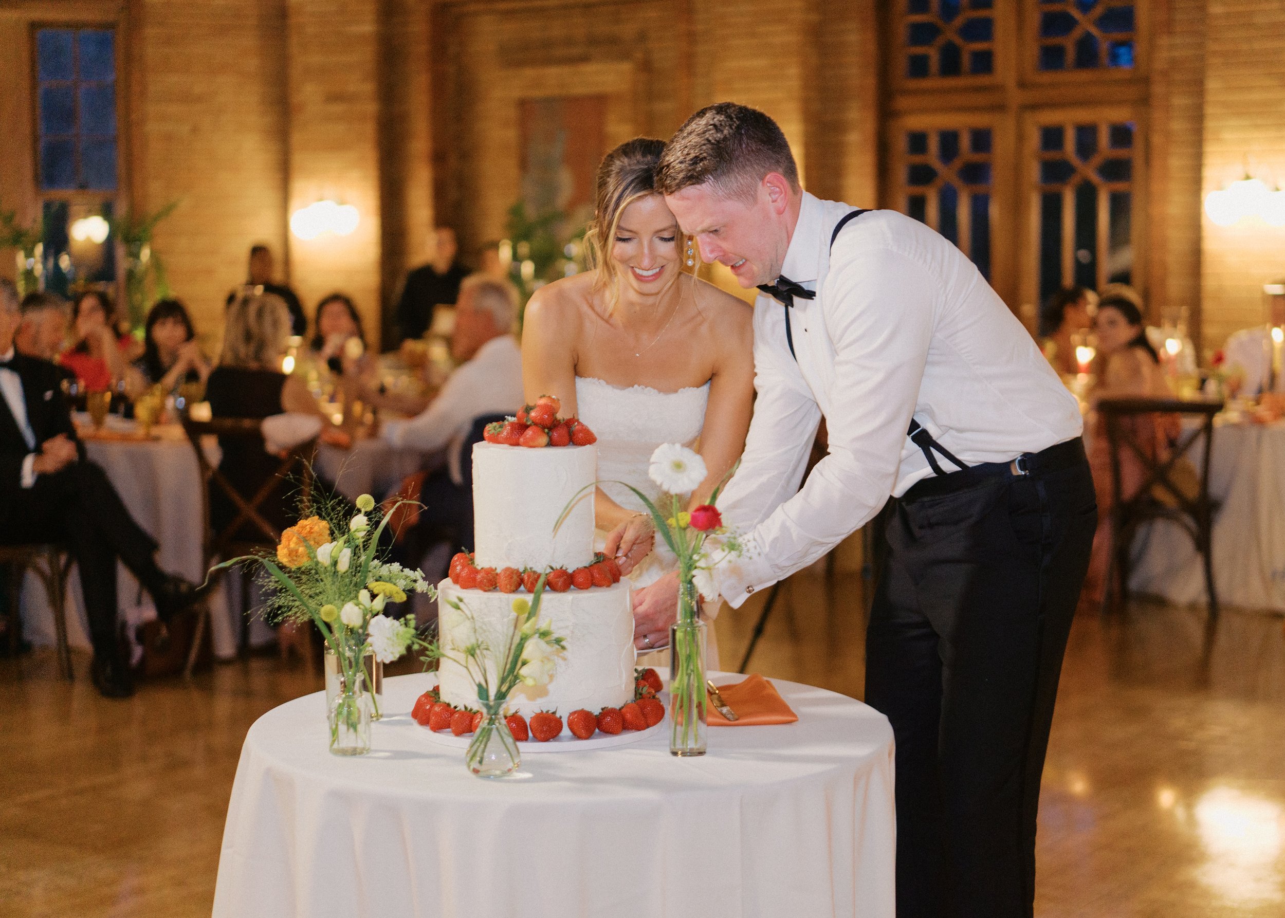 A couple cuts their two tiered wedding cake