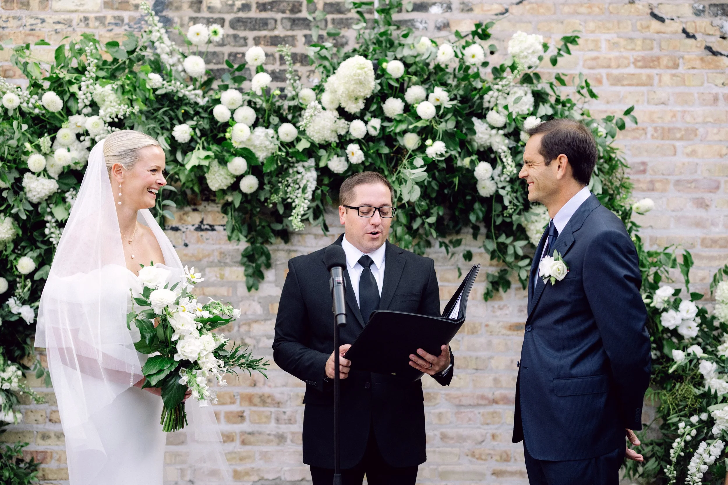 White & green floral structure enhances ceremony vows