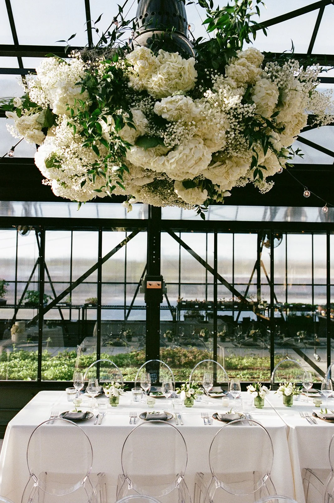 White & Green floral structure suspends over dining tables