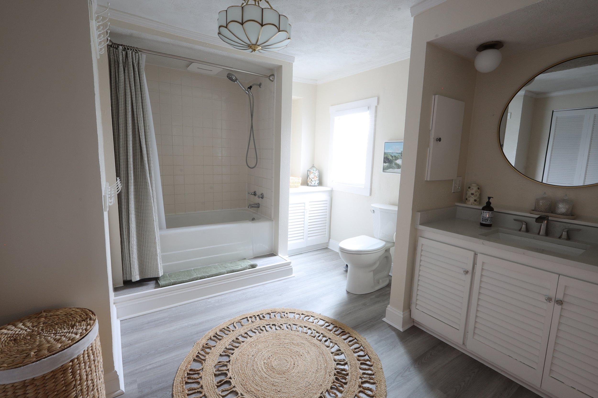 Full bathroom with tub, shower, and full length mirror