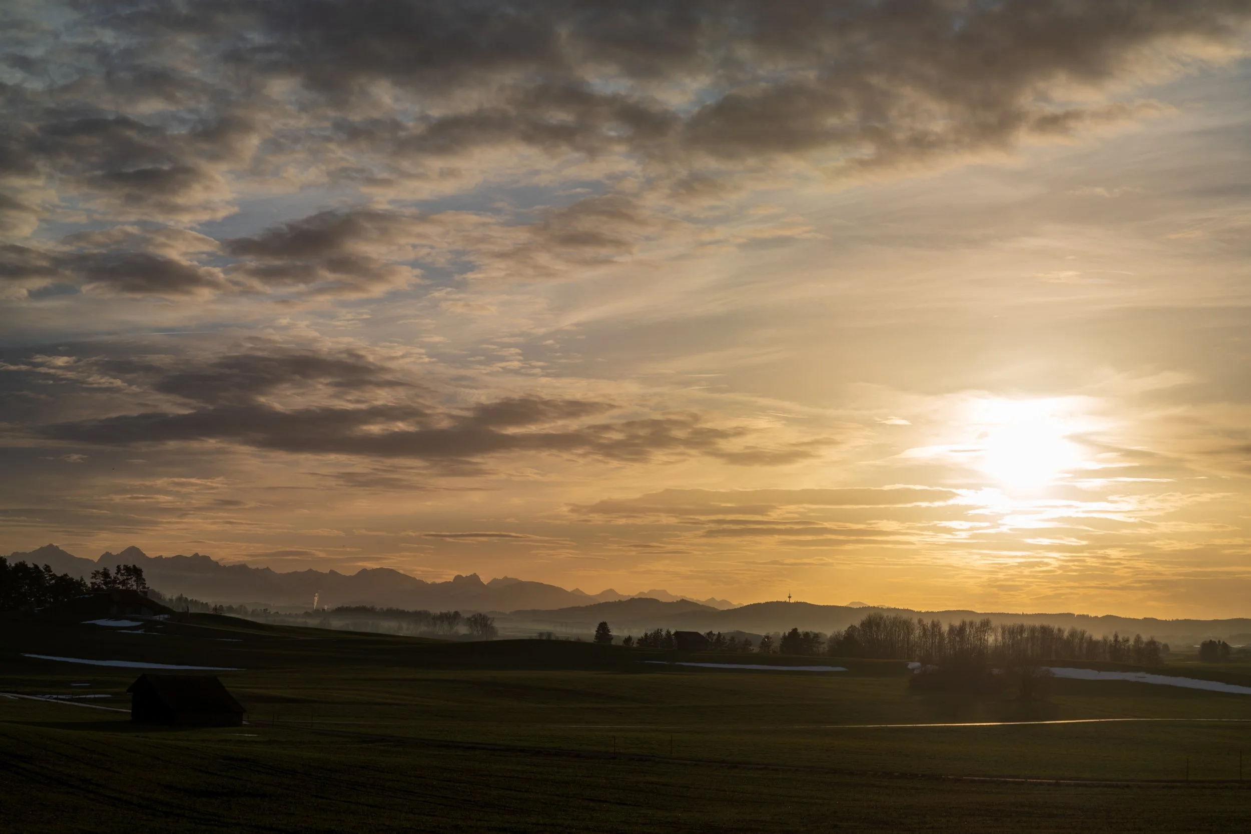 Landschaft im Abendlicht als ruhige visuelle Metapher für nachhaltige und zurückhaltende Gebäudetechnik.