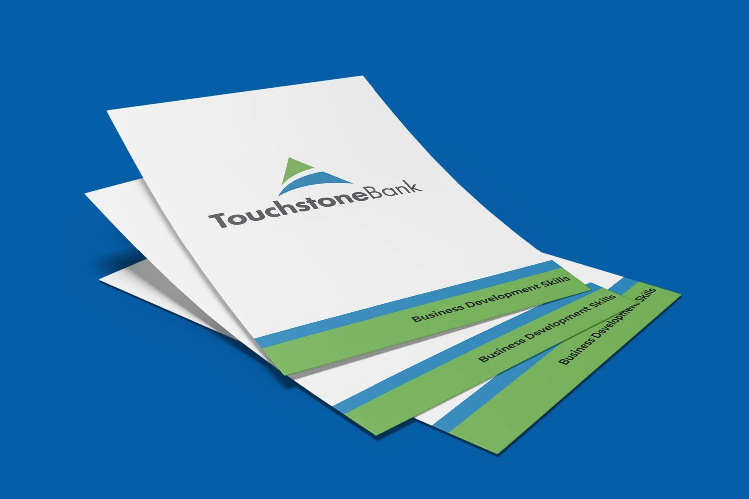Brochures with the TouchstoneBank logo and the text 'Business Development Skills' on a blue background.
