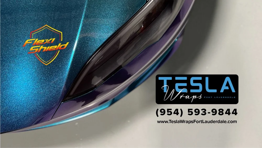 Close-up of a Tesla car with a Fev Shield sticker and a Tesla Wraps Fort Lauderdale advertisement, including contact number and website.