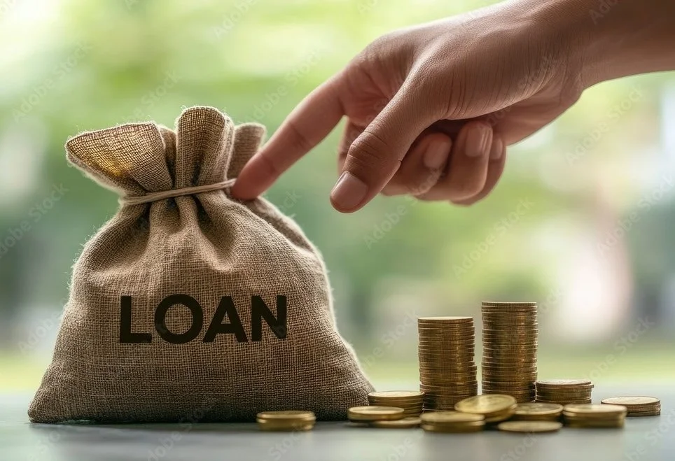 A burlap sack labeled 'LOAN' next to stacks of coins increasing in height, with a hand about to pick up some coins, symbolizing financial loan and savings.