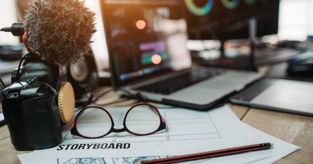 Desk with camera, computer, eye glasses, papers and a pencil