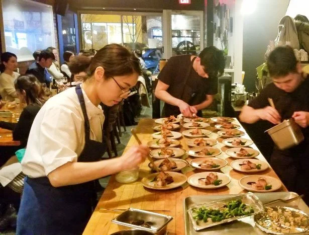 Chefs preparing plates in a restaurant kitchen