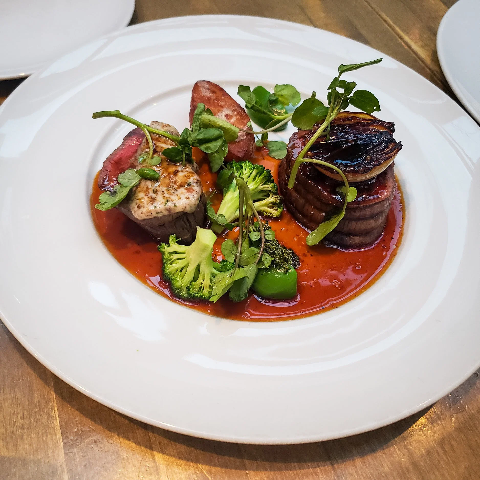 Koreanna Kitchen beef dish with seared tenderloin medallions, broccoli, grilled onion and red sauce