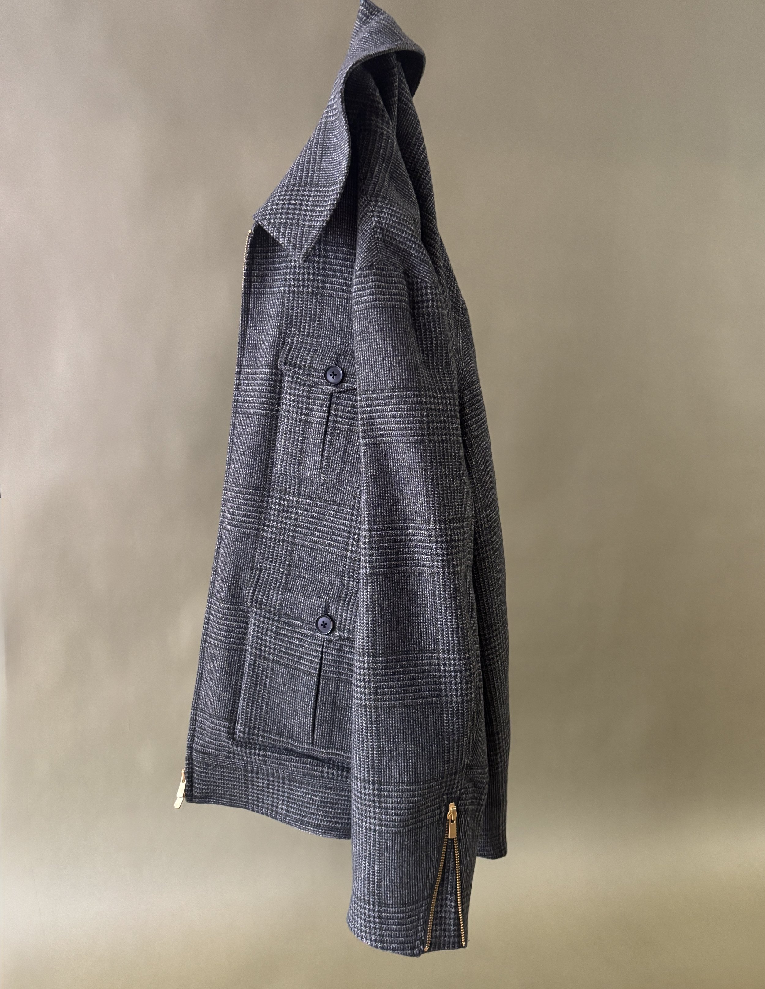 A custom made green plaid bomber jacket in wool and cashmere Drago fabric against a green background.