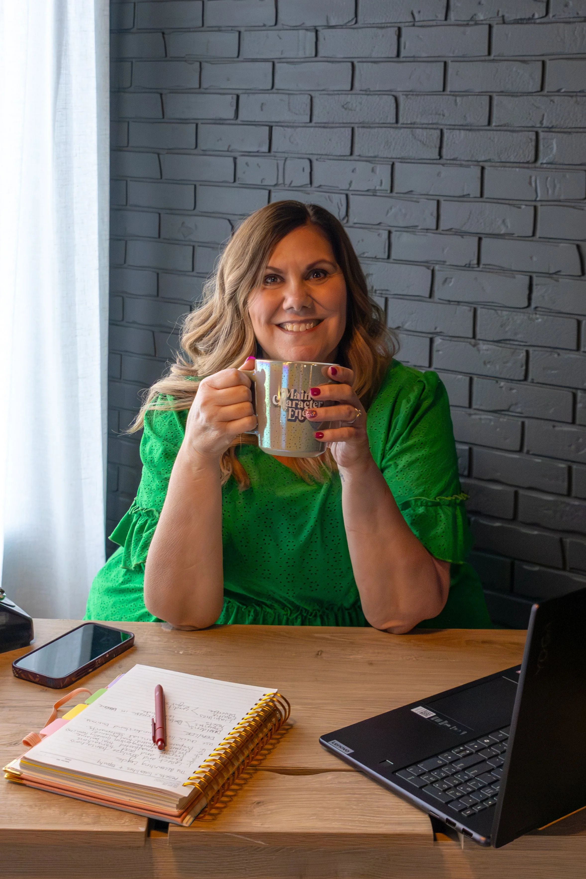 Loni Duncan holds a mug that reads “Main Character Energy,” reflecting her empowering approach to small business bookkeeping.