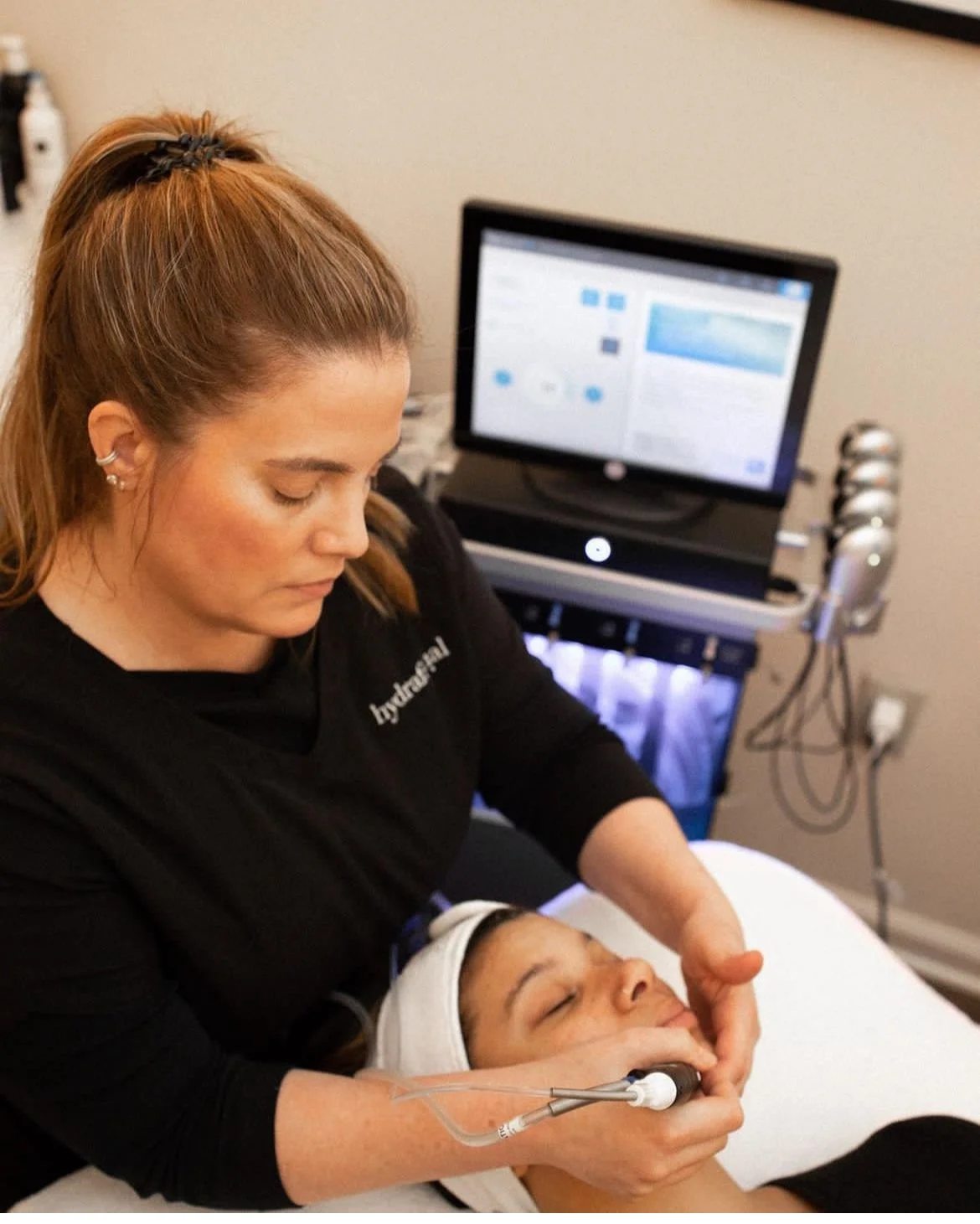 Image of a woman performing a facial on another woman. The picture is of Julie Benecke Lusk a licensed esthetician in Buckhead atlanta