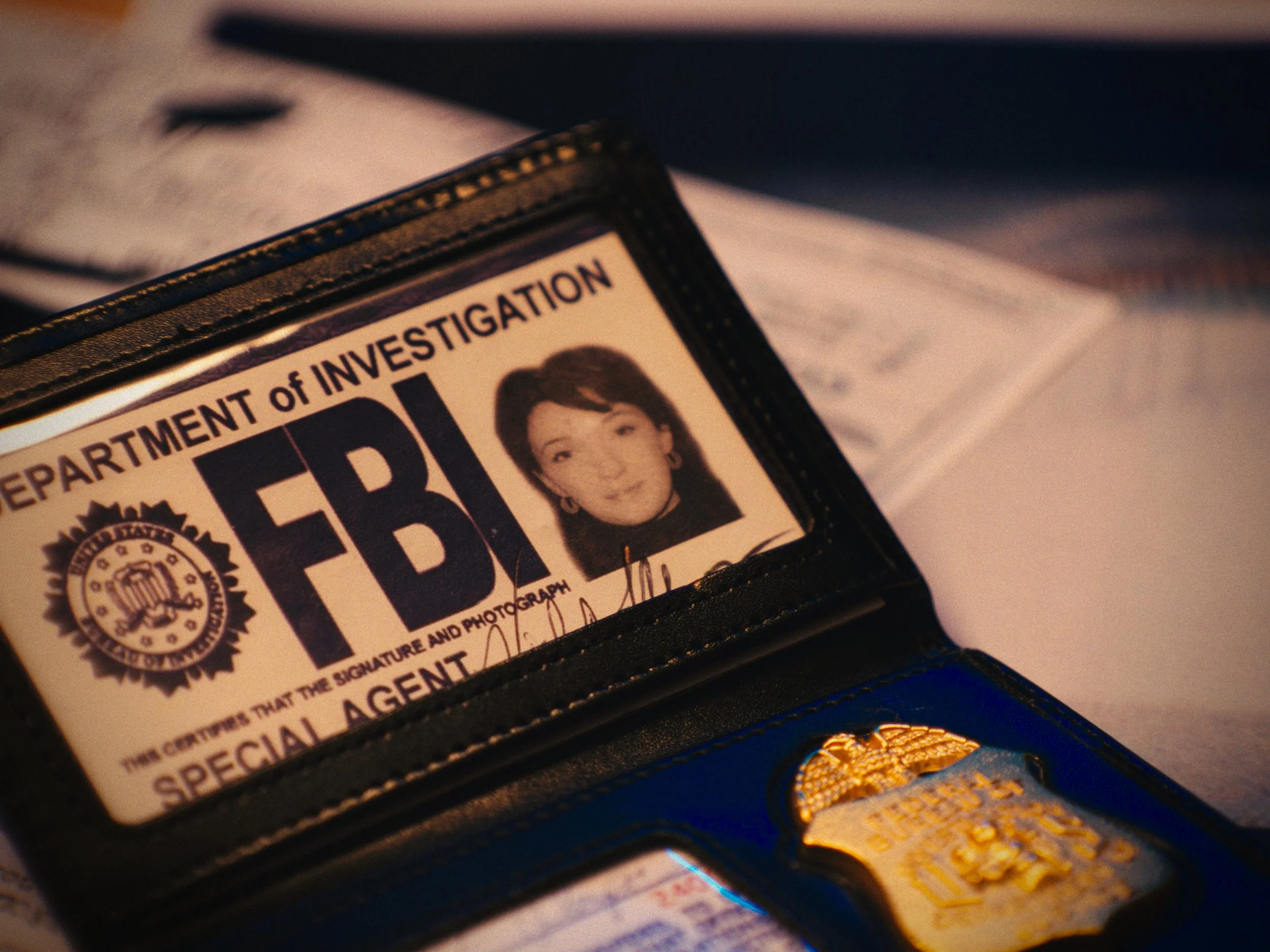 Close-up of an FBI special agent identification badge in a leather wallet, with a photo and official seal visible.