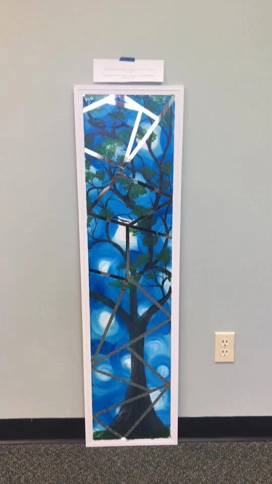 Tall, narrow piece of artwork featuring a stylized tree with a blue sky background, overlaid with white geometric lines and shapes.