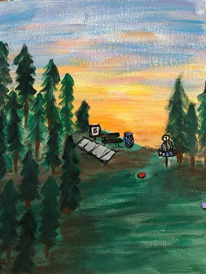 A sunset over a forest with tall pine trees, a camping tent, a table, a barrel, a lantern, and a small red ball on the ground.
