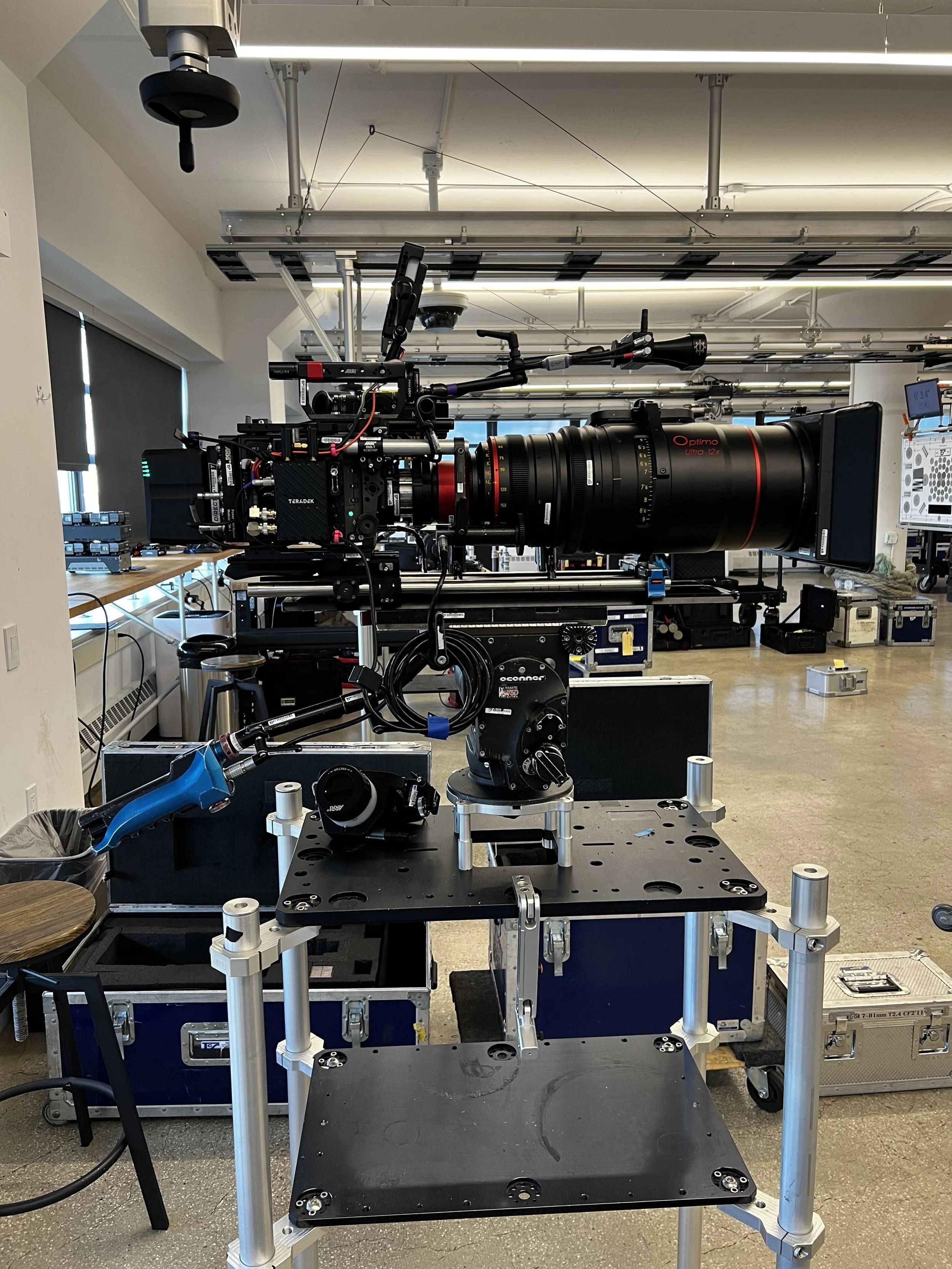 Large professional camera setup on a rig inside a room with equipment and storage cases.