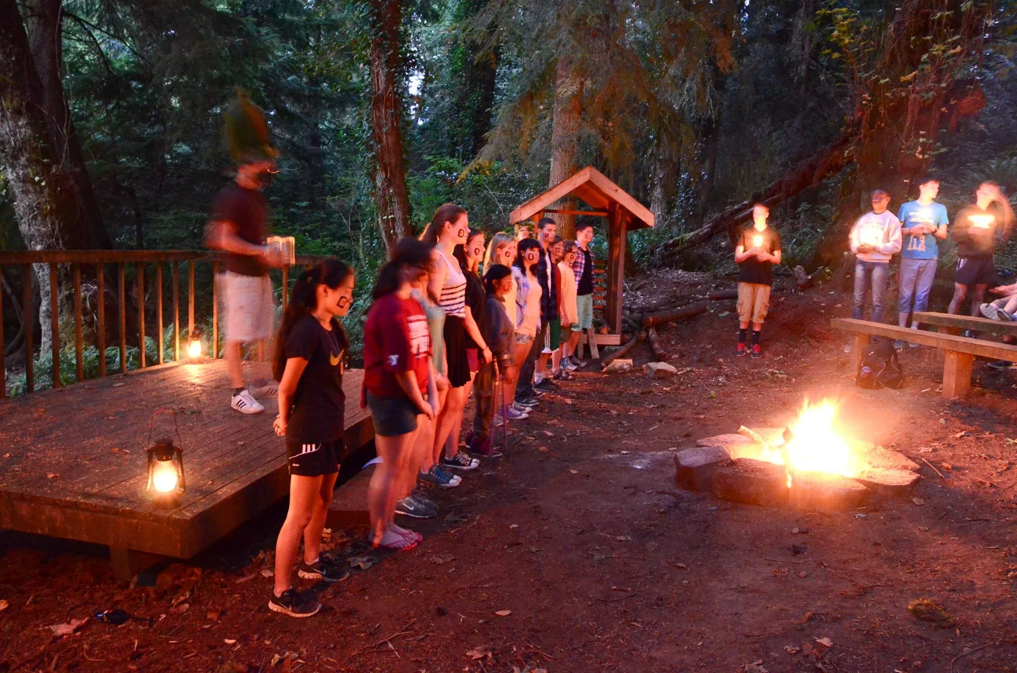 Youth stand by a bonfire
