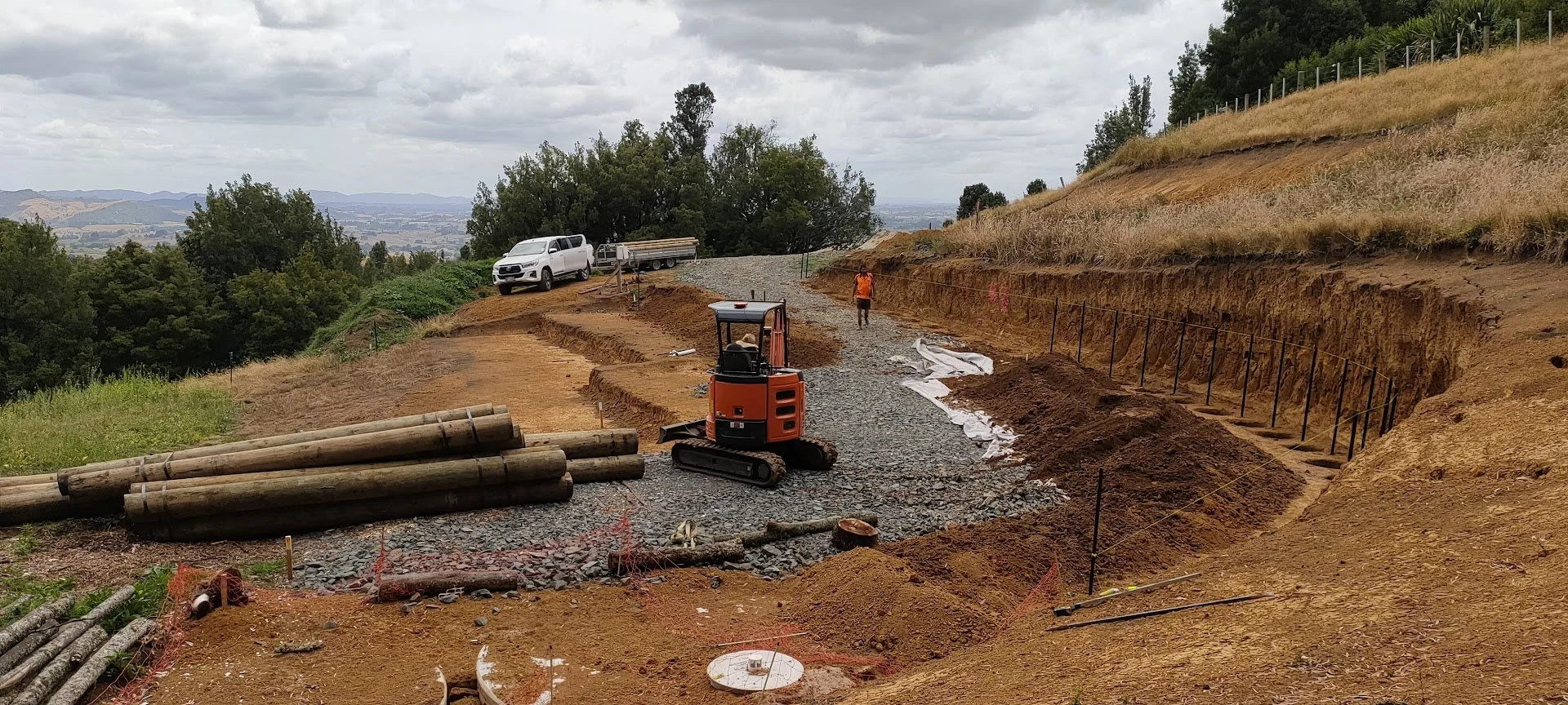 	
Construction site showing  earthworks, levels and  permeable gravel driveway showing the implementation of a site plan designed for this sloping site overlooking Native NZ bush in Pirongia, NZ