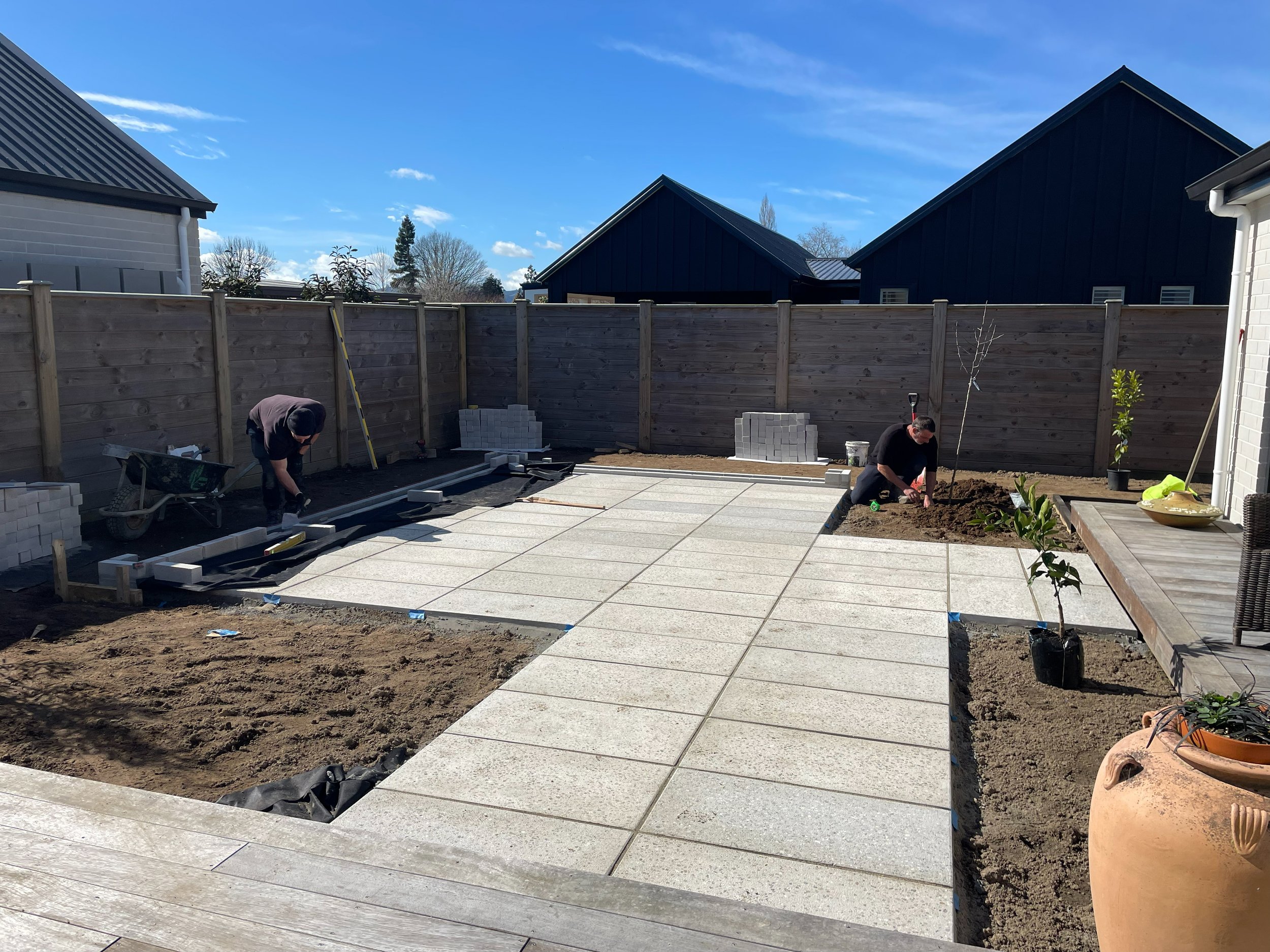Construction of a  modern, fresh courtyard Landscape design featuring a low block wall and handmade  hammered concrete pavers, Cambridge, NZ