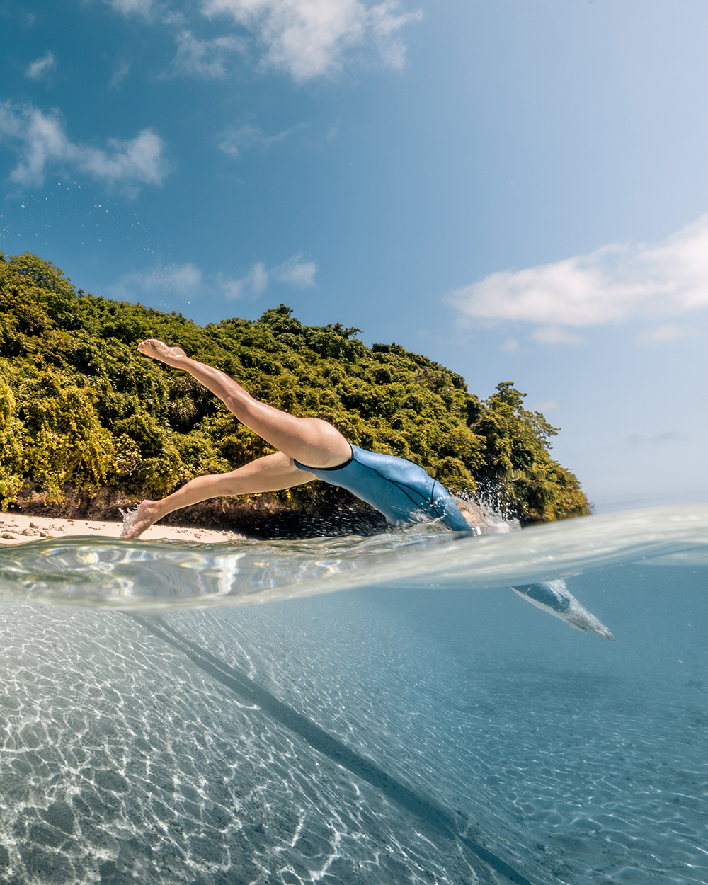 Women diving off beach