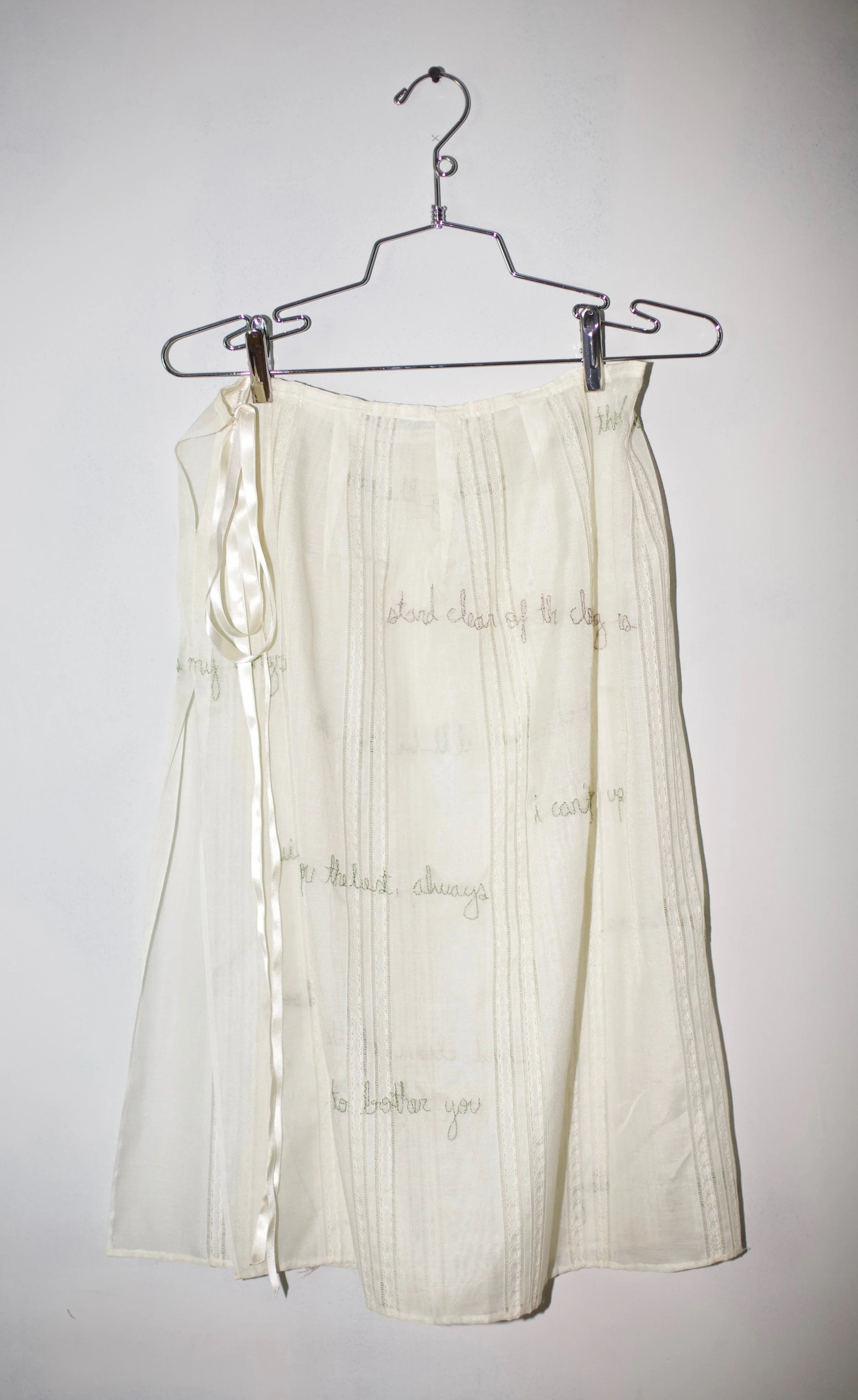 Cut from a secondhand curtain, carefully hand embroidered with collected text from the mundane day to day 