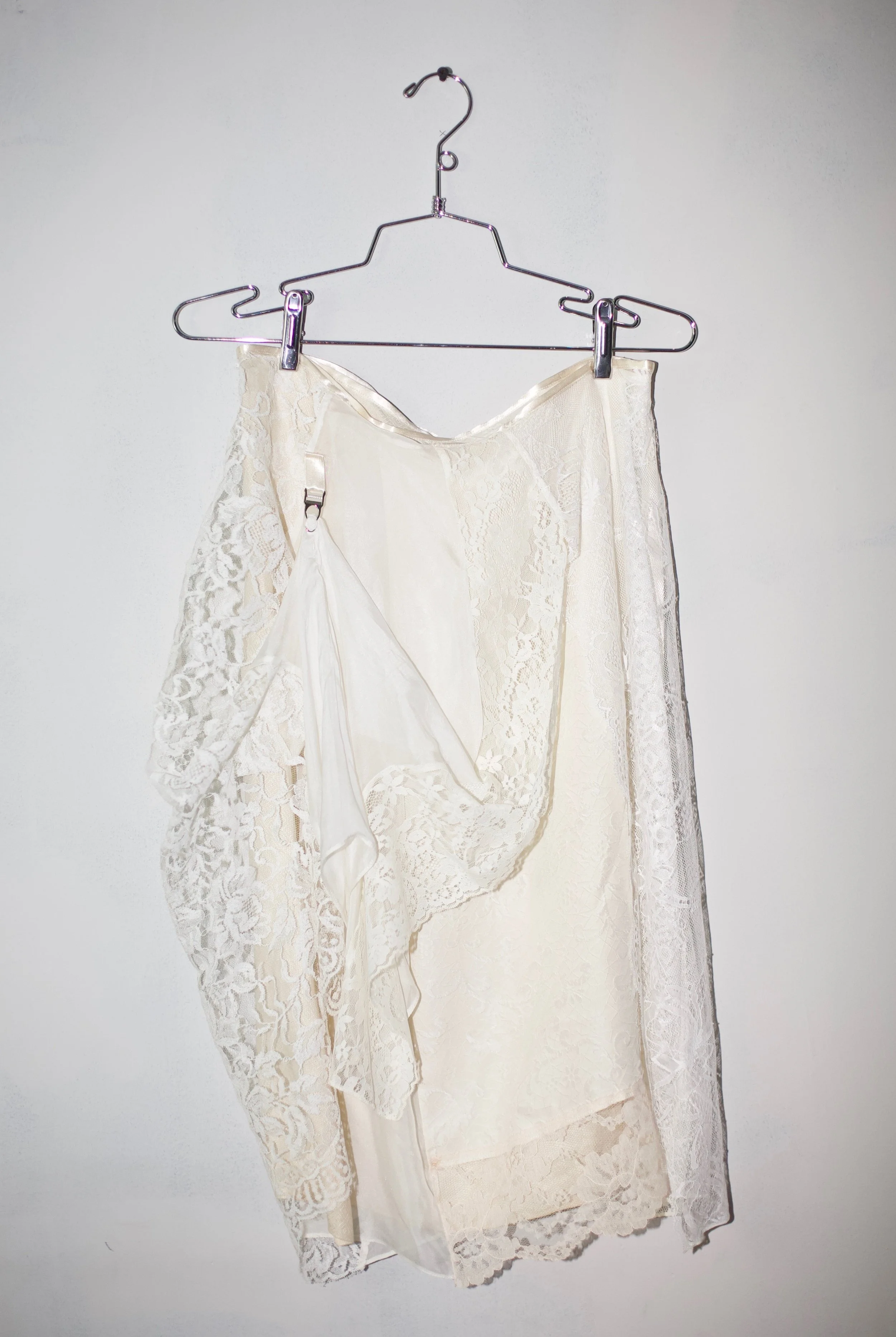 Patchworked deadstock lace, secondhand pillowcase, and lace trim. Garter clip, satin ribbon waist binding.