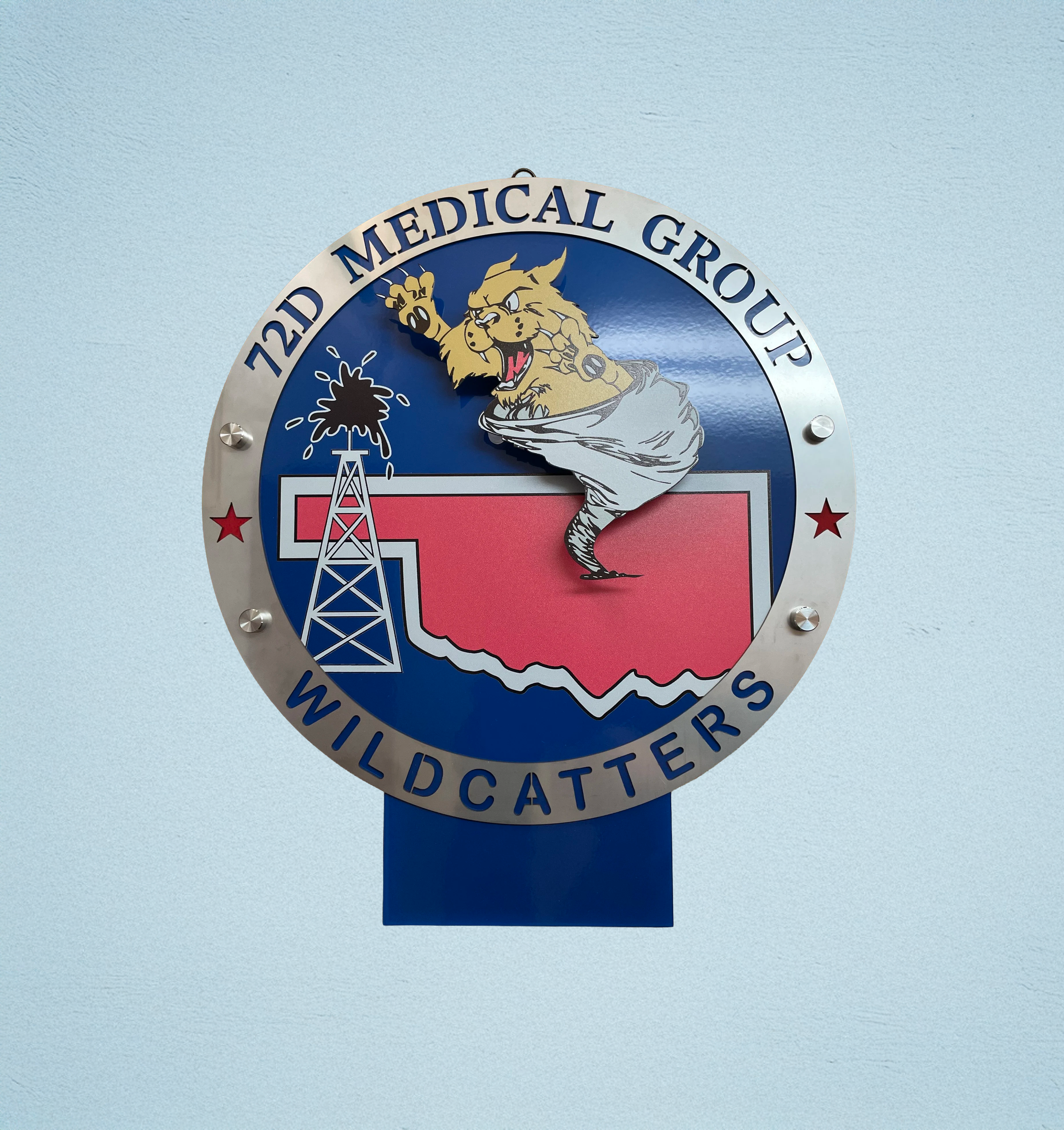 Sign for 72nd Medical Group with a wildcat mascot, a drilling rig, and a map of Oklahoma.