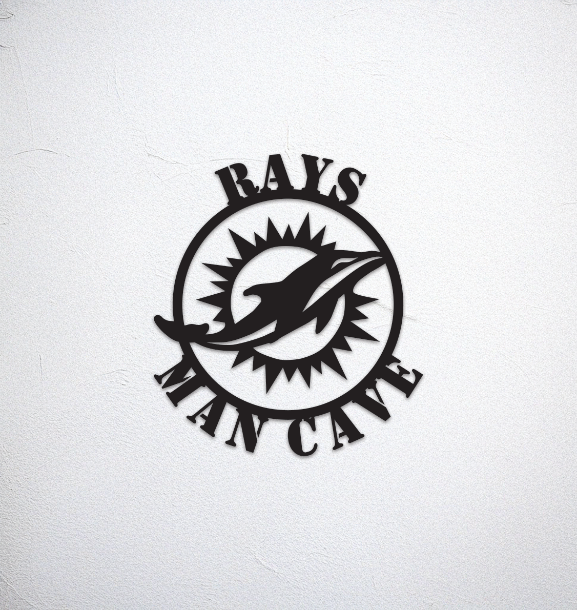Metal wall ornament with the words 'RAY'S at the top and MAN CAVE at the bottom, featuring a dolphine with a sunburst design behind it, mounted on a textured wall.
