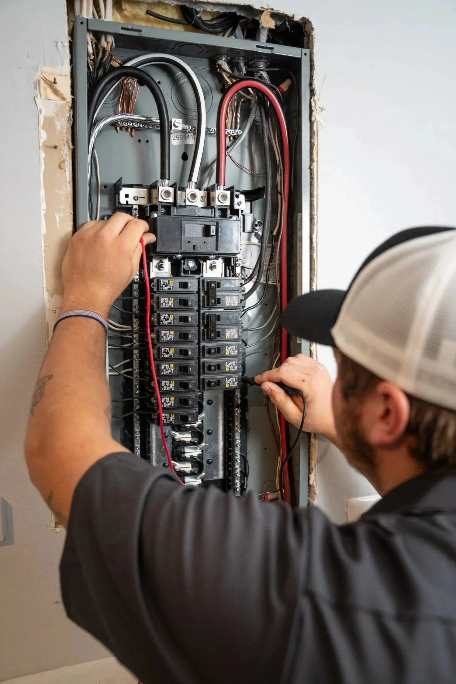 Miracle Electric Electrician tightening connections inside a residential breaker panel