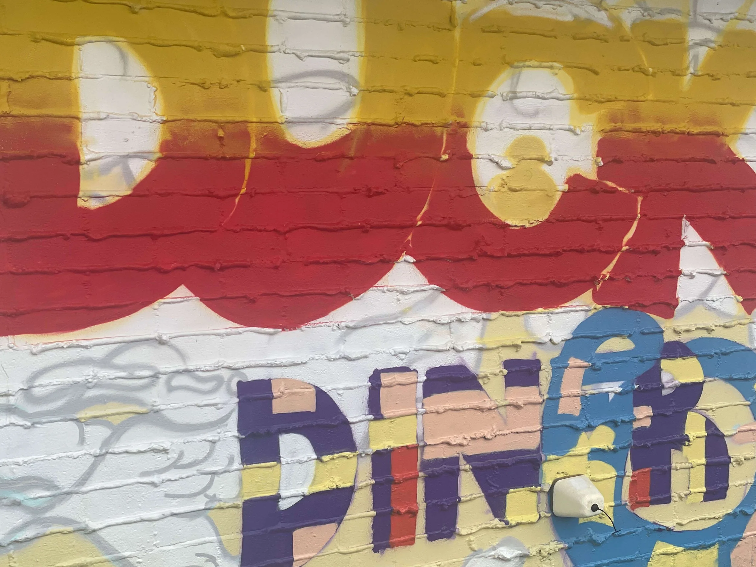 Close-up of mural lettering in progress on Duck’s Diner wall, showing red and yellow gradient, Gulf Shores AL, 2025.