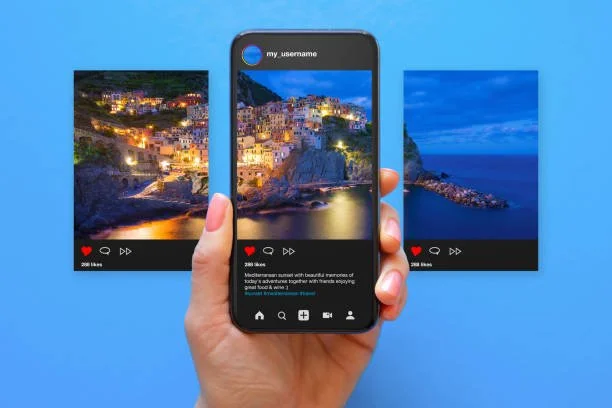 Person holding smartphone capturing an image of two landscape photographs on a blue background.