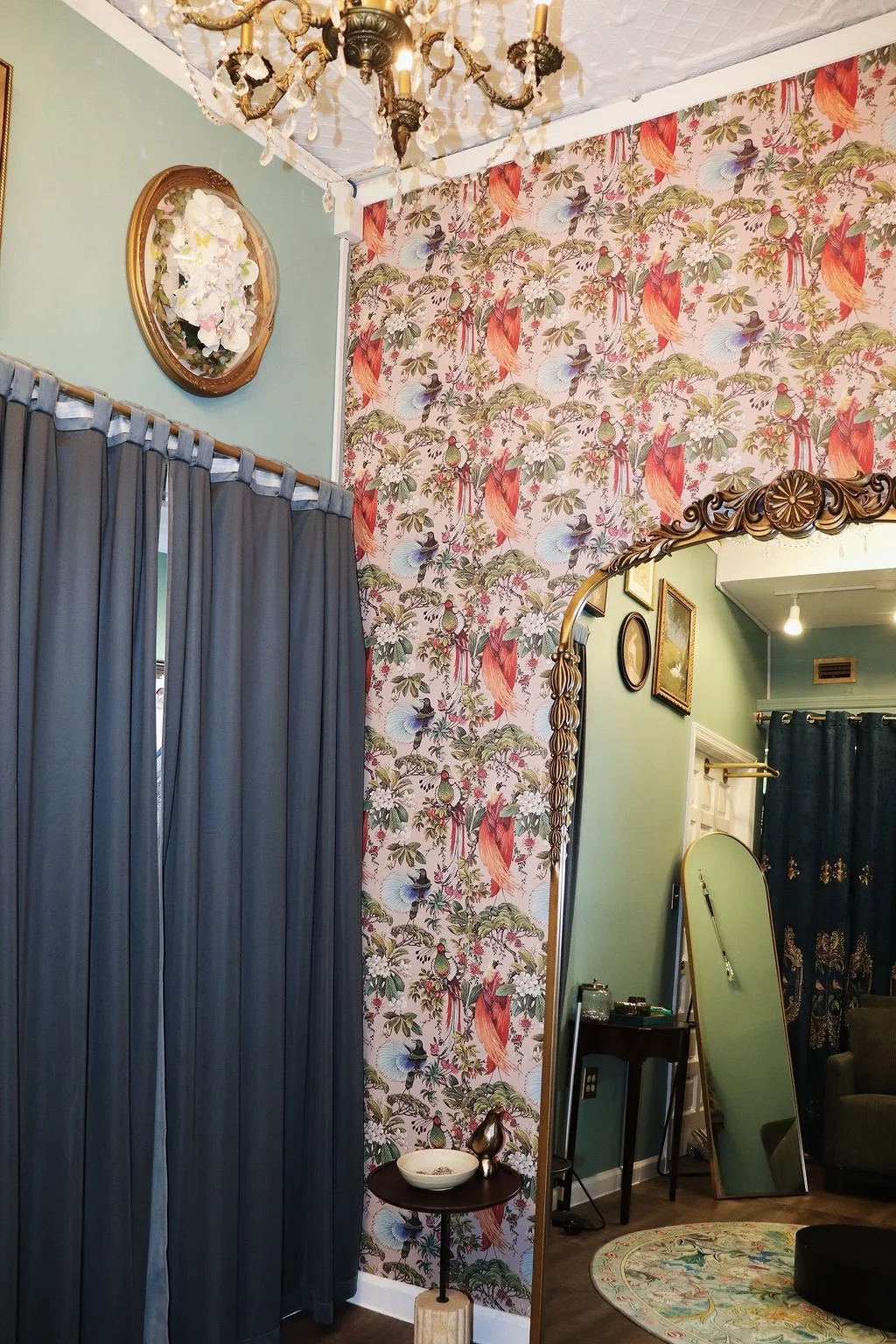 Fitting room with grey curtains and a chandelier