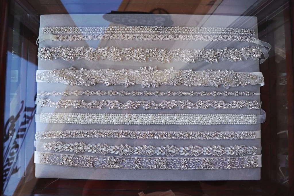 Crystal and pearl bridal belts laid out in rows