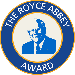 Seal of the Royce Abbey Award featuring a portrait of a man in a suit, with the text 'The Royce Abbey Award' around the border.