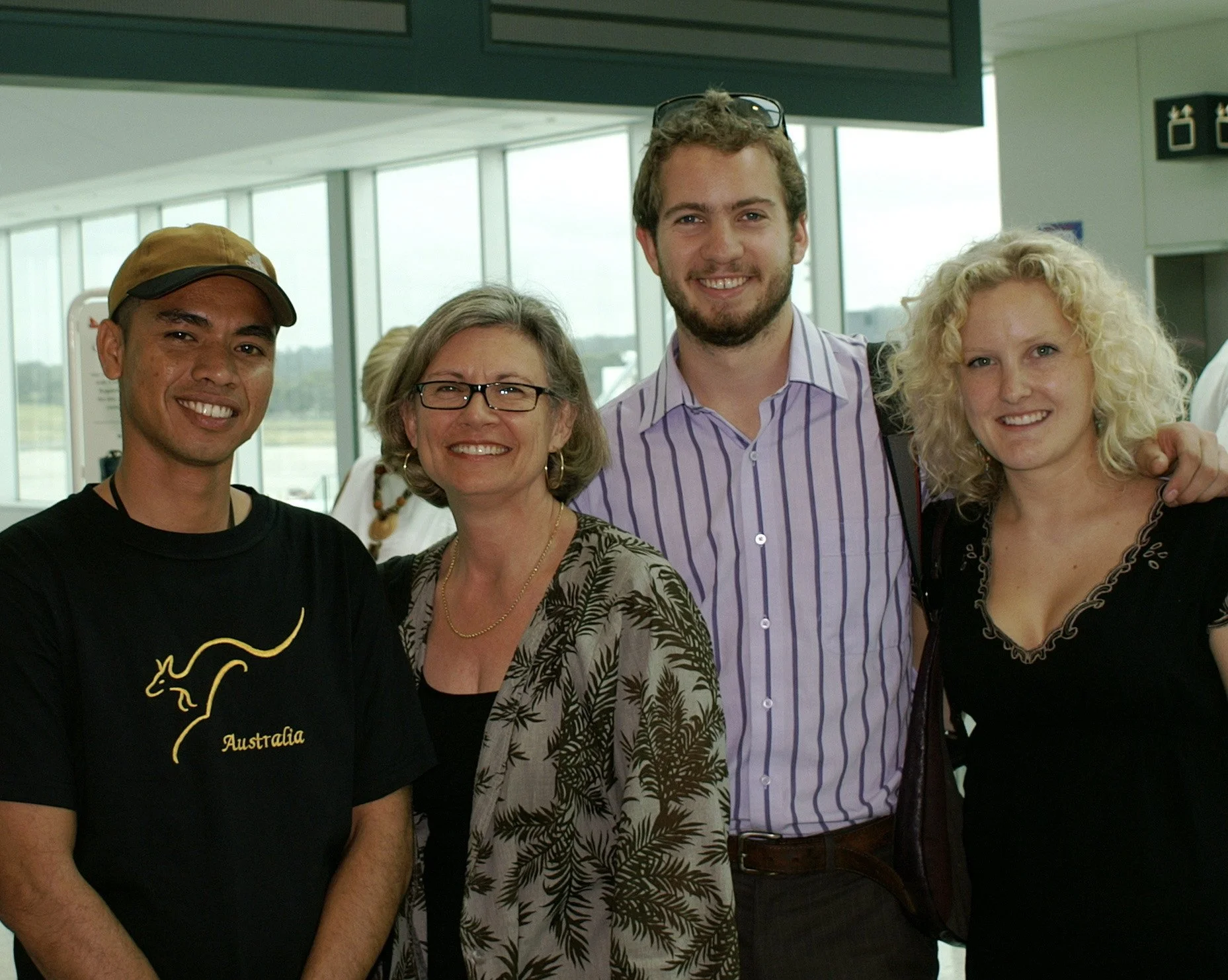 Group of four smiling people in an airport