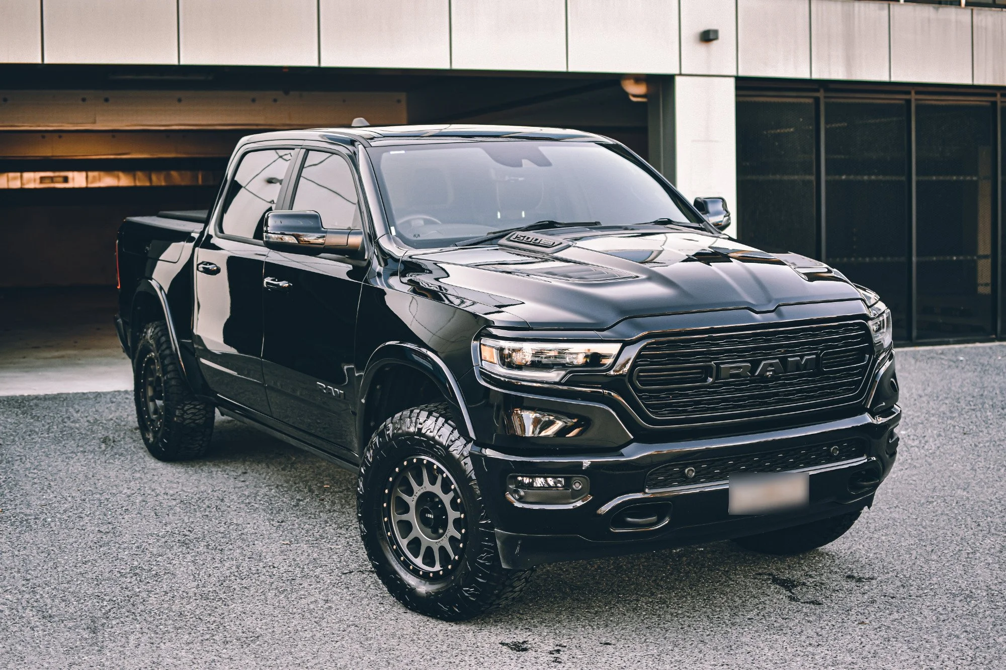 Black pickup truck parked outside a modern building.