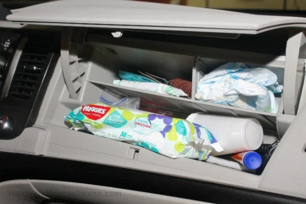 Open glove compartment with various medical supplies and tissues inside.