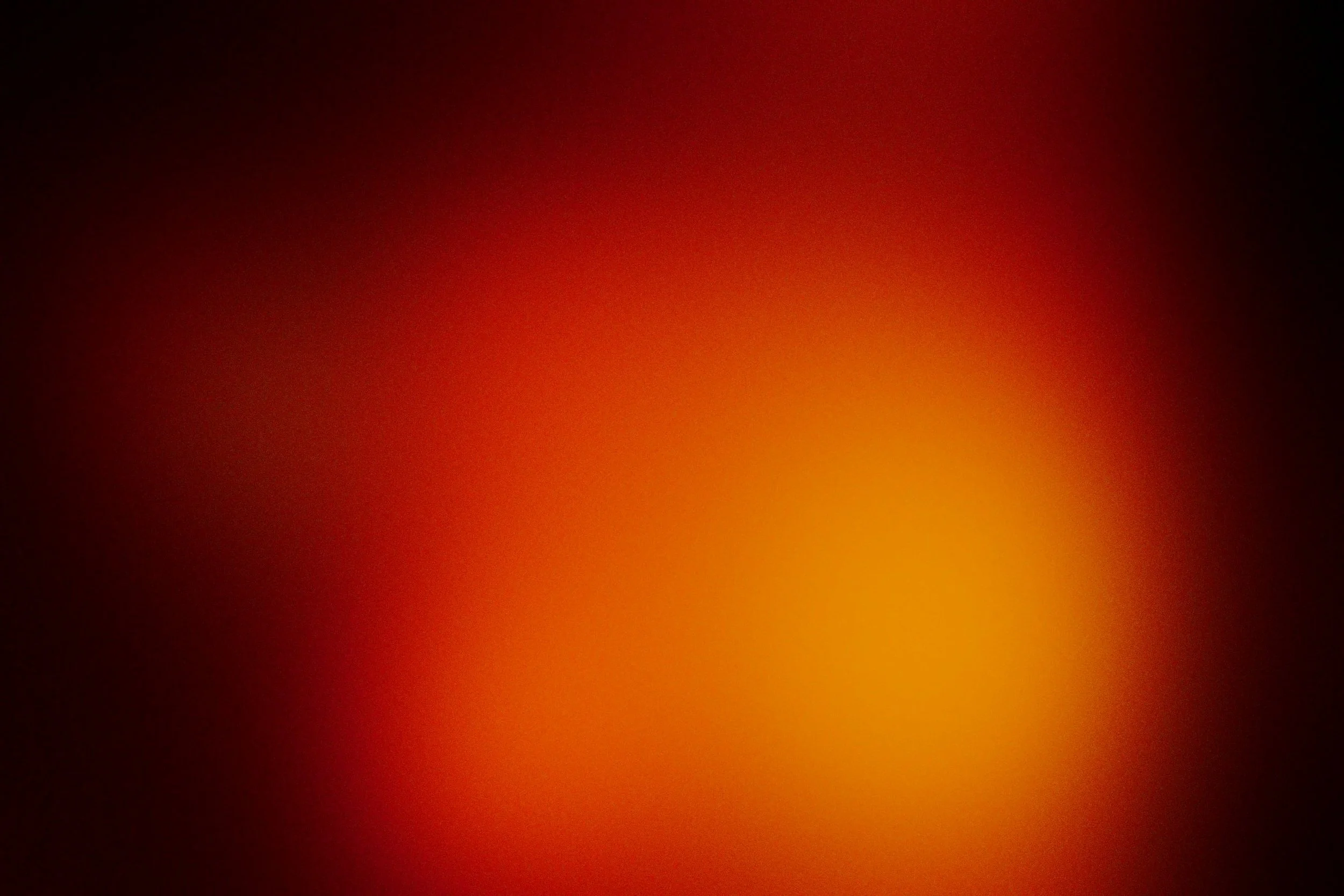 Blurred abstract image with red, orange, and black colors.