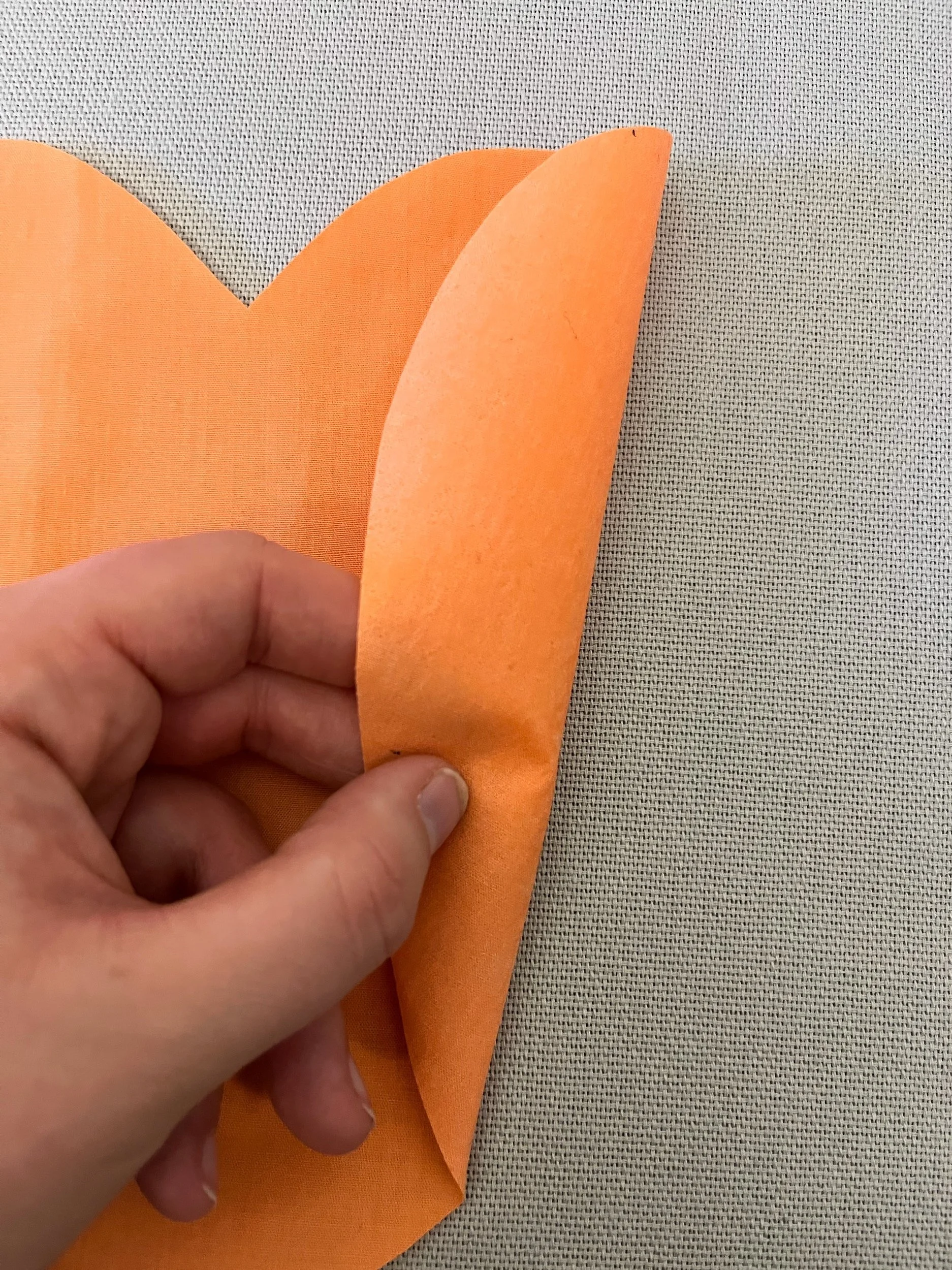 3. Taking your largest heart (should be a darker shade of your chosen colour) peel the paper from the back, it feels a bit like tracing paper and leaves a 'shiny glue' on the reverse of the heart. This 'gluey' side should be against the cushion cover