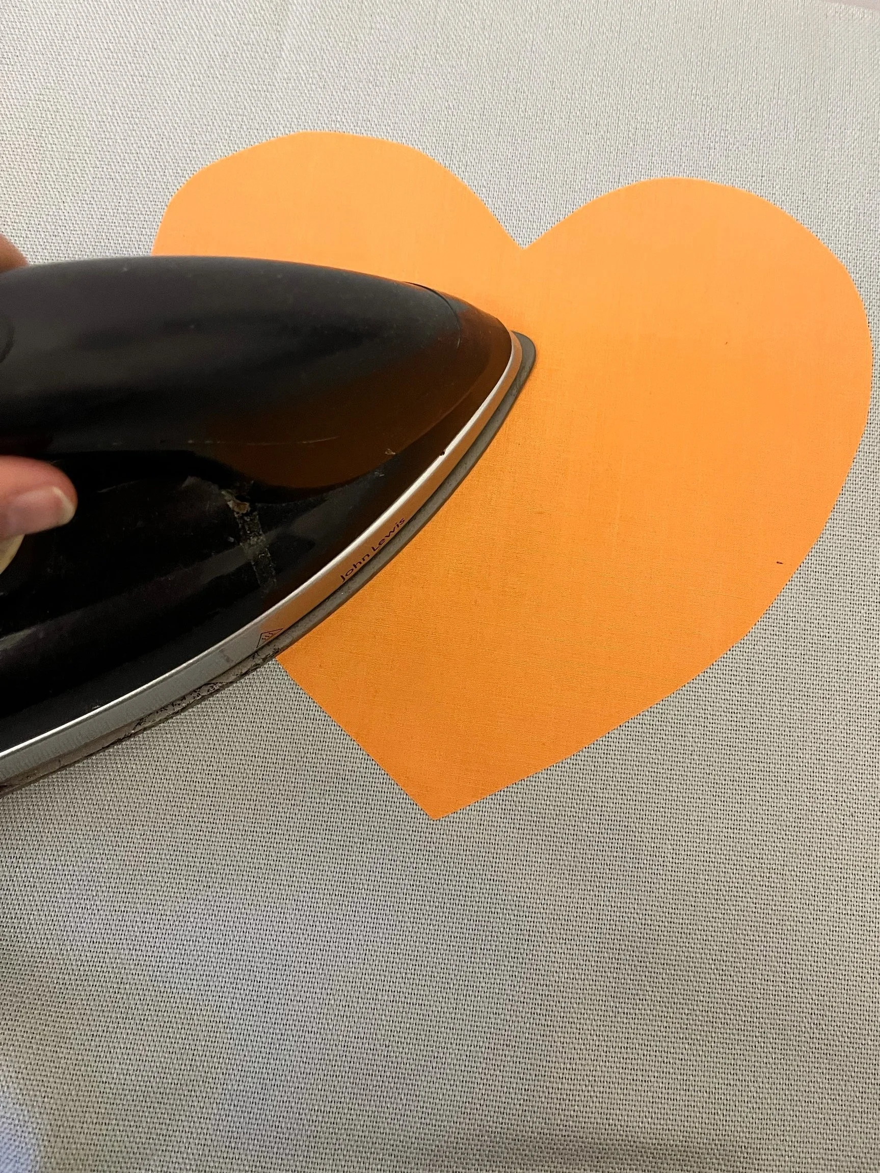 4. Place the heart in the middle of the cushion and centralise where you would like it to appear (remember it will be 3D when you've put the cushion inside!) 
Check again that the 'shiny gluey' side is against the cushion cover and iron over the top 