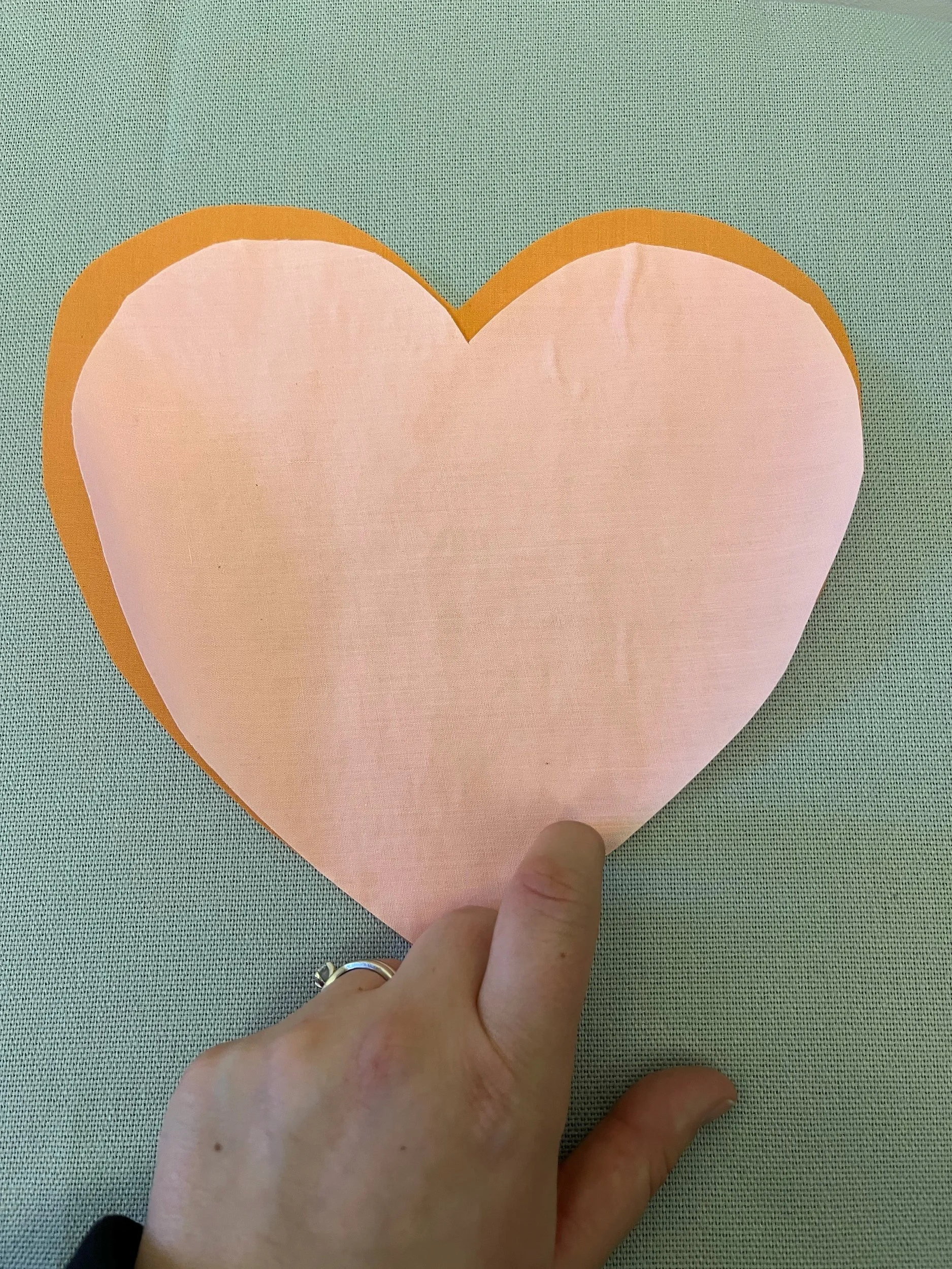 6. Again, make sure that the 'shiny gluey' side is down against the first heart and not facing your iron. Line up the smaller heart so that it leaves a 'shadow' of the larger one behind. The right-hand side of the smaller heart should line up with th