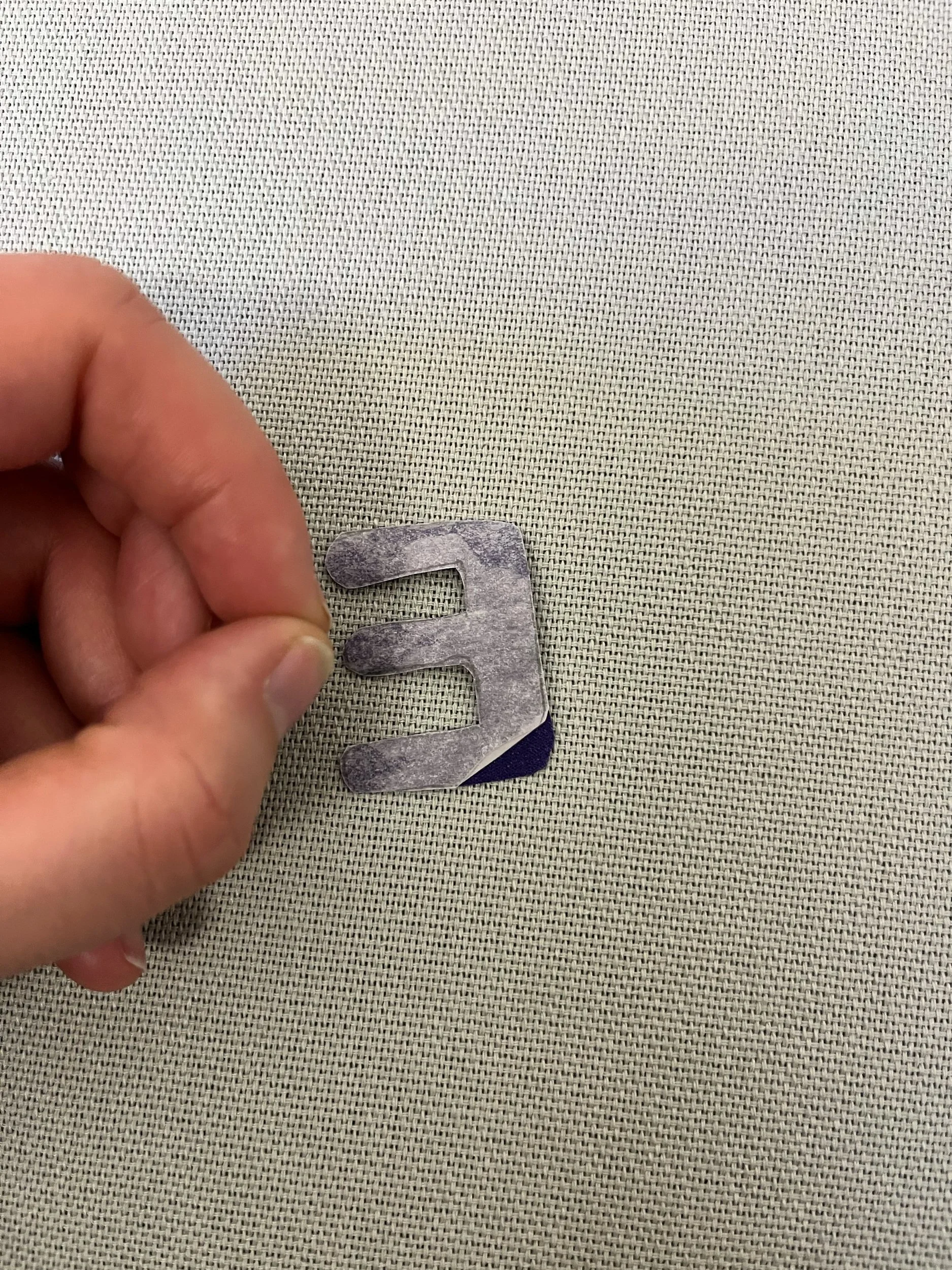 8. Next you want to start peeling the paper from the back of all the letters. Be careful not to remove the 'glue' here and if any does come away just press it down again with the finger. If you're struggling to peel the paper off, try 'crushing' one 