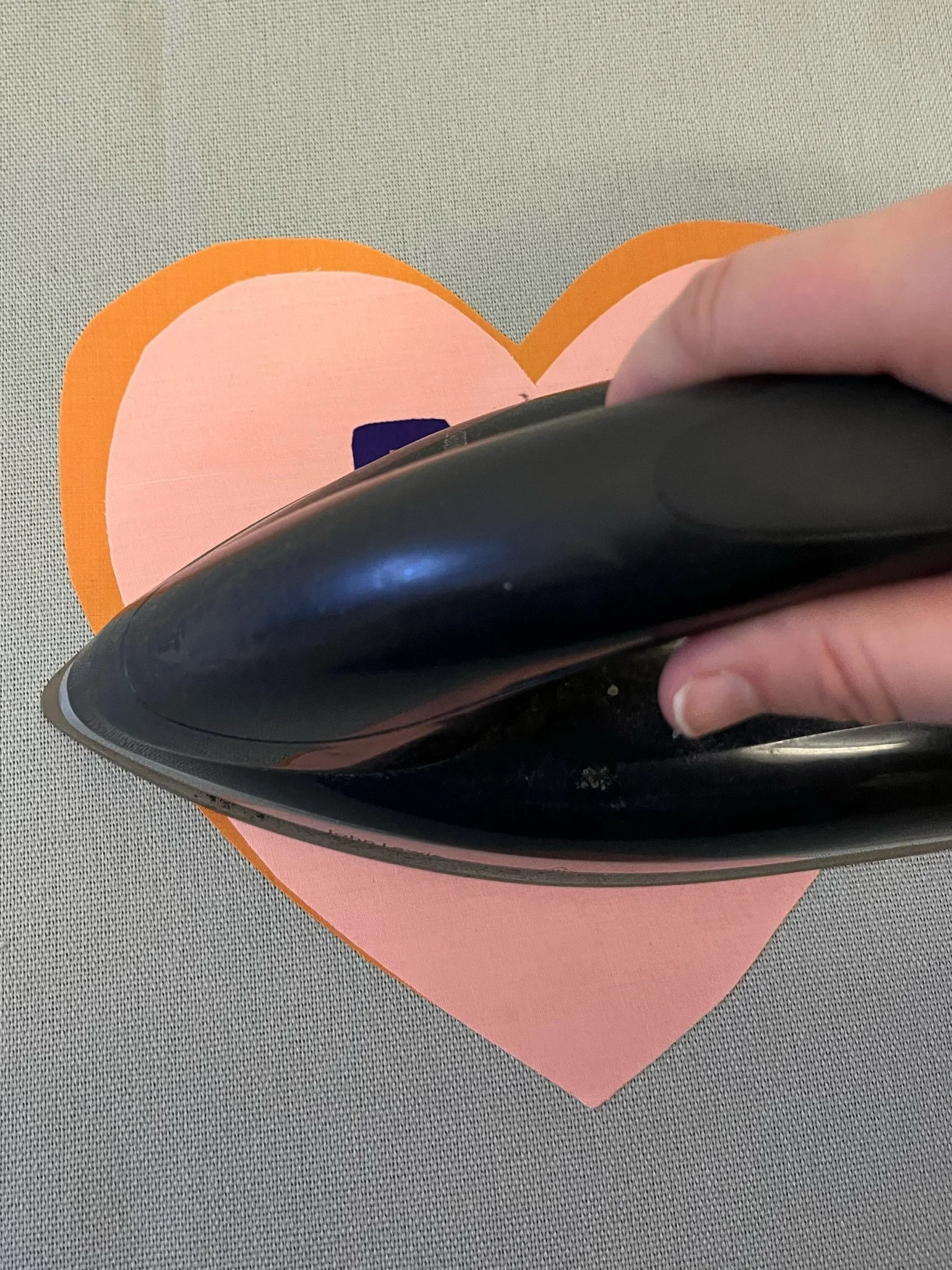 10. Carefully place your iron over the top of the letters, making sure they haven't moved out of place and iron for a few seconds to bond the letters to the hearts. 