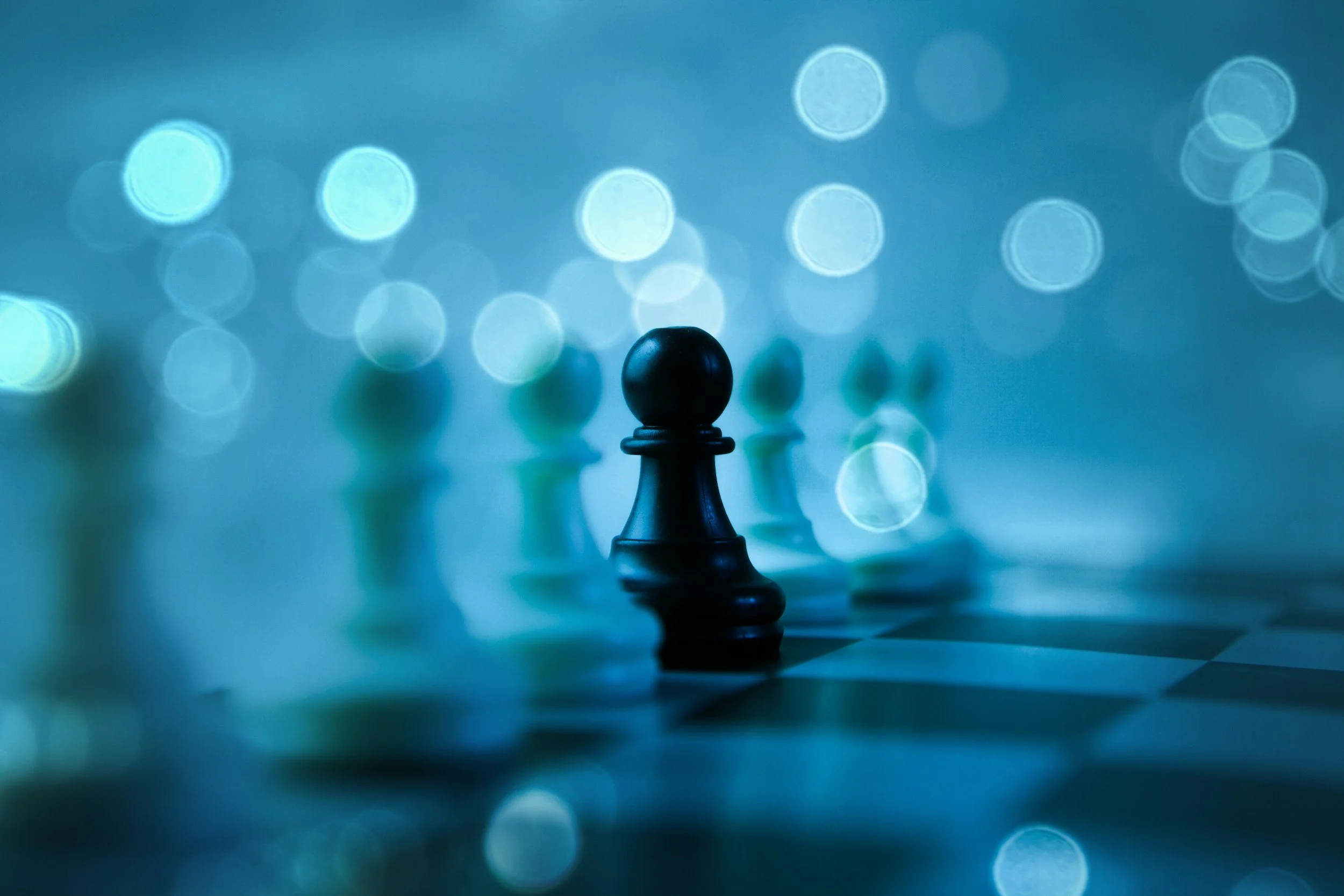 A knight chess piece on a chessboard with a blue bokeh background.