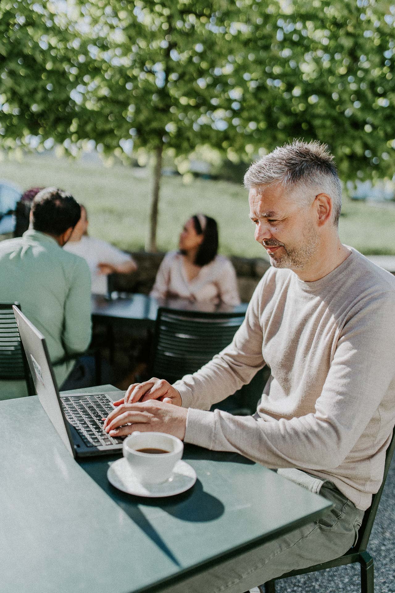 Reklamefotografering til kampanje for Altibox bedrift tatt i naturlig lys utstein kloster hotell en som jobber på pc utendørs på restaurant